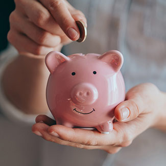 woman putting coin in piggy bank