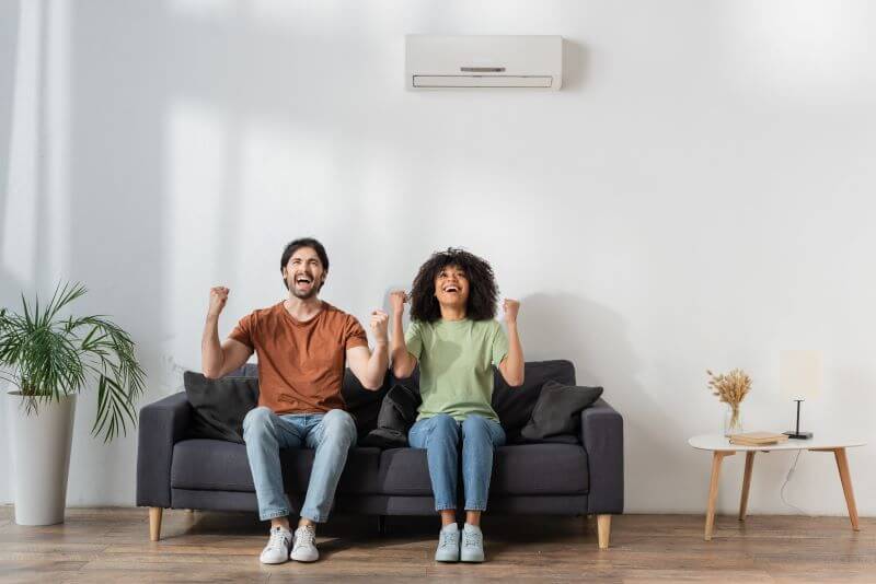 happy couple on couch wall hvac unit